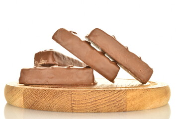 Several sweet chocolate bars on a round wooden tray, close-up, isolated on white.