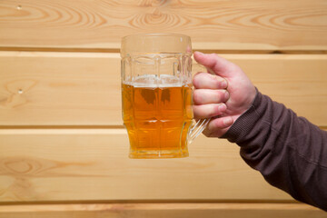 Beer glass mug with beer in the hands of a person.