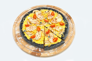 Whole meat black dough Pizza served on wooden plate, isolated on white background. Fast food With chicken slices, gouda cheese, blue cheese, champignon mushrooms and cherry tomatoes
