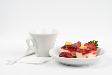 white cup expresso of coffee with strawberries and purple flowers on a table ready for breakfast italian pastries