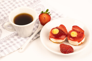 white cup expresso of coffee with strawberries and purple flowers on a table ready for breakfast italian pastries