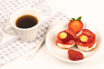 white cup expresso of coffee with strawberries and purple flowers on a table ready for breakfast italian pastries
