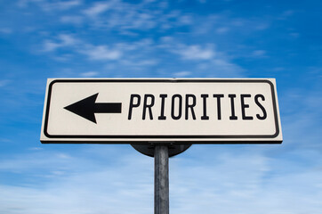 Fototapeta premium Priorities road sign, arrow on blue sky background. One way blank road sign with copy space. Arrow on a pole pointing in one direction.