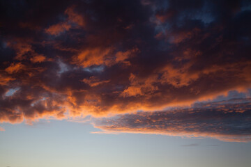Sunset sky in the dusk with fiery clouds