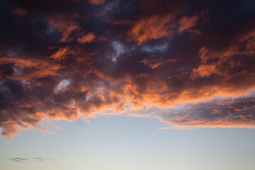 Sunset sky in the dusk with fiery clouds and copy space