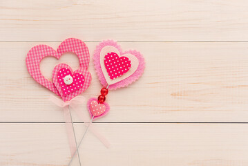 Two hearts made of fabric on a white wooden surface