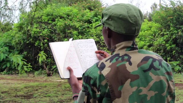 African soldier flipping the pages on his plan of attack booklet