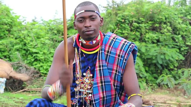 young Maasai man tapping his staff to beat of music