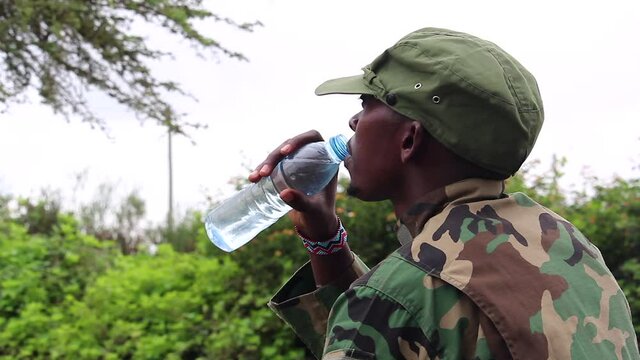 African militant geurilla sipping warter on hot day