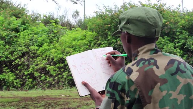 African militant guerilla going over attack plan in booklet