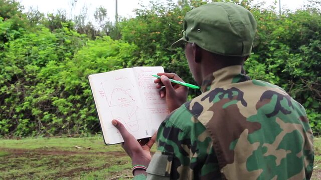 African soldier studying his notebook