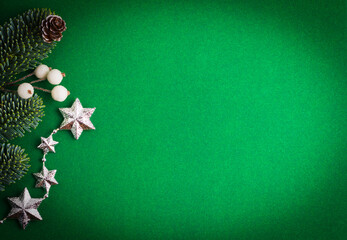 Fototapeta na wymiar Green background with Christmas tree, pine cone, stars and beads.