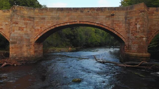 drone shot, flying underneath the bridge revealing another side