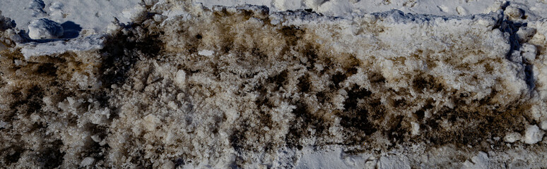 Badly stained texture on the snowy road 