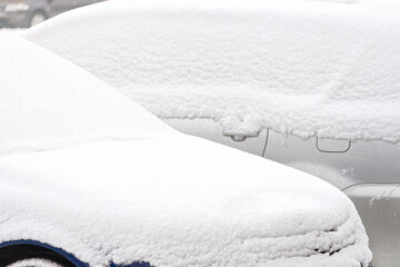 Cars covered with snow parked in the yard of residential apartments house