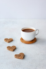 Cup of coffee with three pieces of heart shapet bread