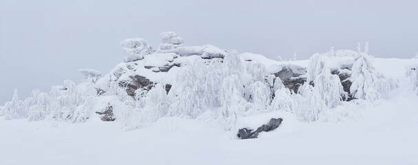 snow-covered rocks and frost-covered trees on a mountain pass in winter