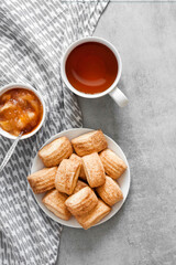 Tasty breakfast. Homemade sweet cinnamon cookies, cup of tea and apple confiture. Flatlay