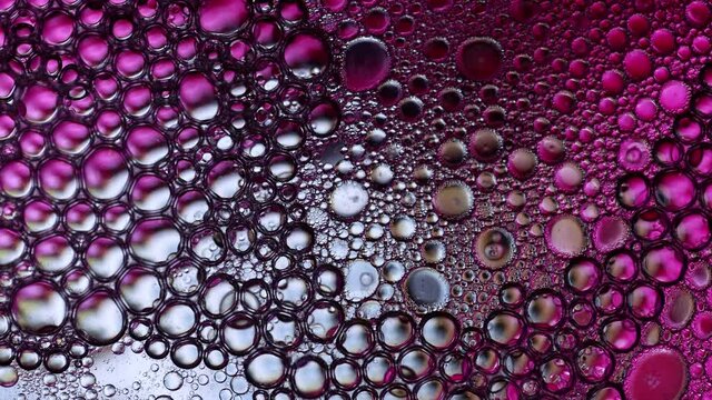 Colorful view in macro of bubble popping in liquid.