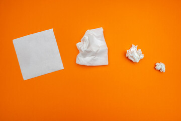 paper towels that are arranged in the order in which they are crumpled. paper towels are arranged on an orange uniform background