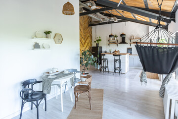 stylish kitchen interior design. white walls and wooden decoration. beautiful hammock and high windows.