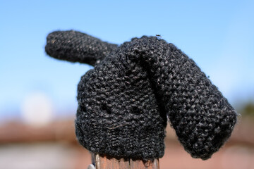 Knitted Glove Is Lonely On Wooden Peg - Mitten