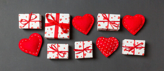 Top view colorful valentine background made of gift boxes and red textile hearts. Valentine's Day concept with copy space