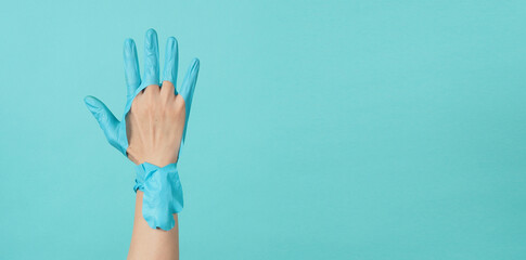 Close up of hand Wearing torn medical gloves or torn rubber gloves on blue and green  or Tiffany...