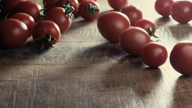 Rolling tomatoes on wooden table