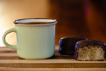 Taza de café junto a pasteles  de mazapán con chocolate