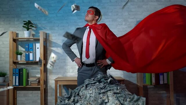 male businessman in superhero costume flying banknotes