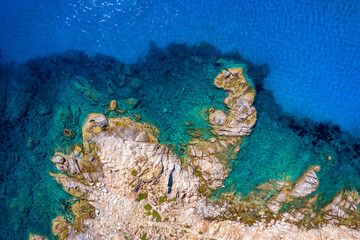 Plakat Aerial photo over granite rocky coastline Mediterranean crystal clear blue sea water. Aerial photo of ocean waves hitting rocky coastline of beautiful paradise dream tropical beach. Sardinia, Italy.