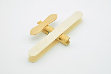 Avión de madera hecho con palos de helado y pinzas de la ropa, aislado sobre fondo blanco
