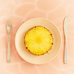 The concept of a healthy breakfast for weight loss and taking care of the figure. Pineapple diet for fat burning. Round piece of juicy pineapple on a pink plate on a pink background. Exotic snack