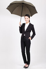 A young business woman holding an umbrella 