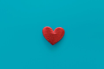 Red heart on blue background. Central composition. Love and passion minimal concept