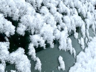 Fresh snow and snowflakes on the top of red car windows after early December snowfall in Vermont, USA