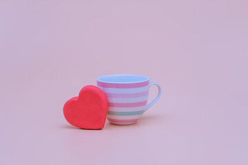 Big red heart and a cup on pink background. Love, wedding and happy valentine minimal concept. Copy space