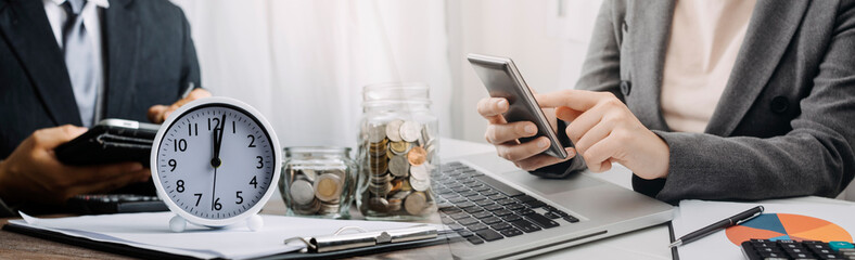 businesswoman holding coins putting in glass with using smartphone and calculator to calculate concept saving money for finance accounting