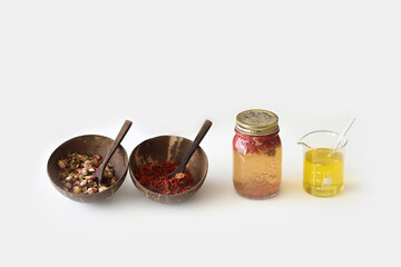 Dried flowers in bowls and oil cans of plant extracts on a white background and copy space
