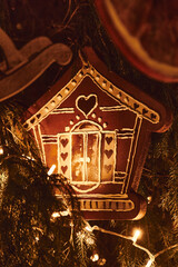 Vertical photography of Gingerbread house and golden Christmas Fir Tree Decoration With Gold Ornaments with garland lights