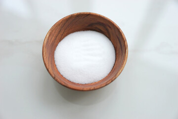 Salt in wooden bowl on marble white background