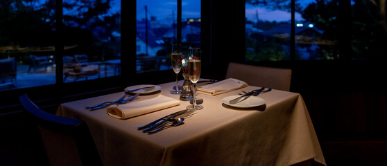 夜のフレンチレストラン　シャンパングラスとテーブルセッティング