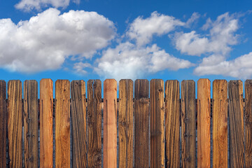 Wooden fence with cloudy blue sky