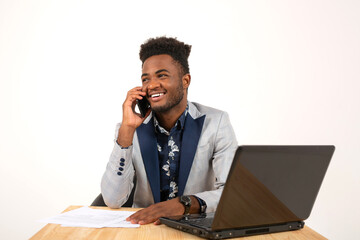 handsome young african male at table with laptop