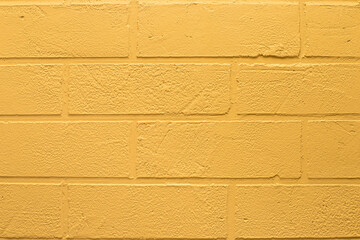 Brick wall. Decorative plaster in the form of a brick, painted yellow. Interior of premises