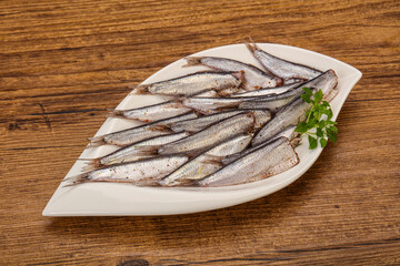 Anchovies in the bowl served basil leaves