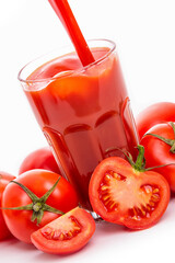 Tomato juice in a glass and tomatoes with green sepals