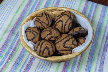 Dark chocolate butter cookies in a straw basket.