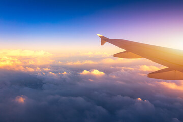 Flying and traveling, view from airplane window on the wing on sunset time. Aircraft wing under the...